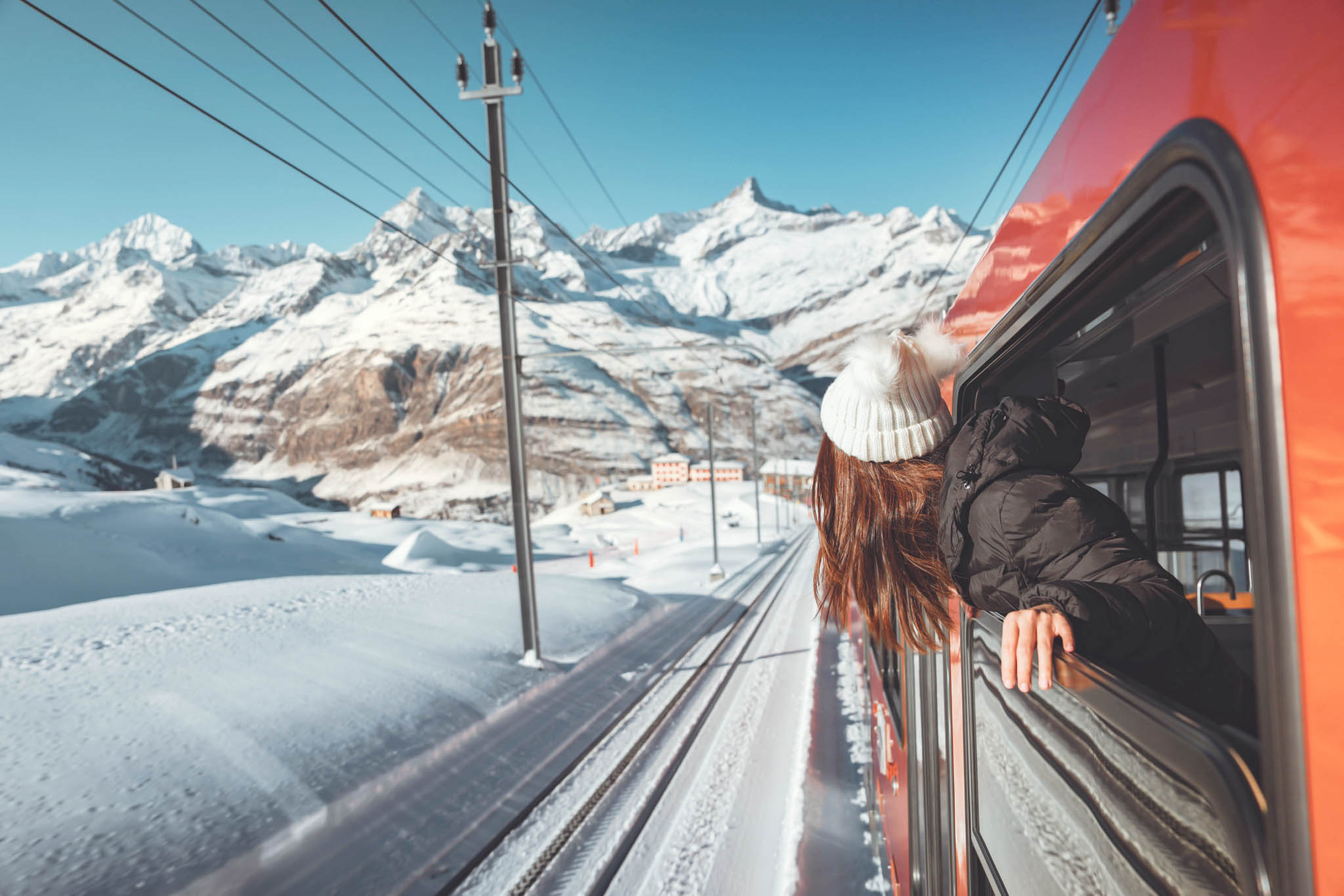 Wintersport met de trein, vrouw hangt uit het raam